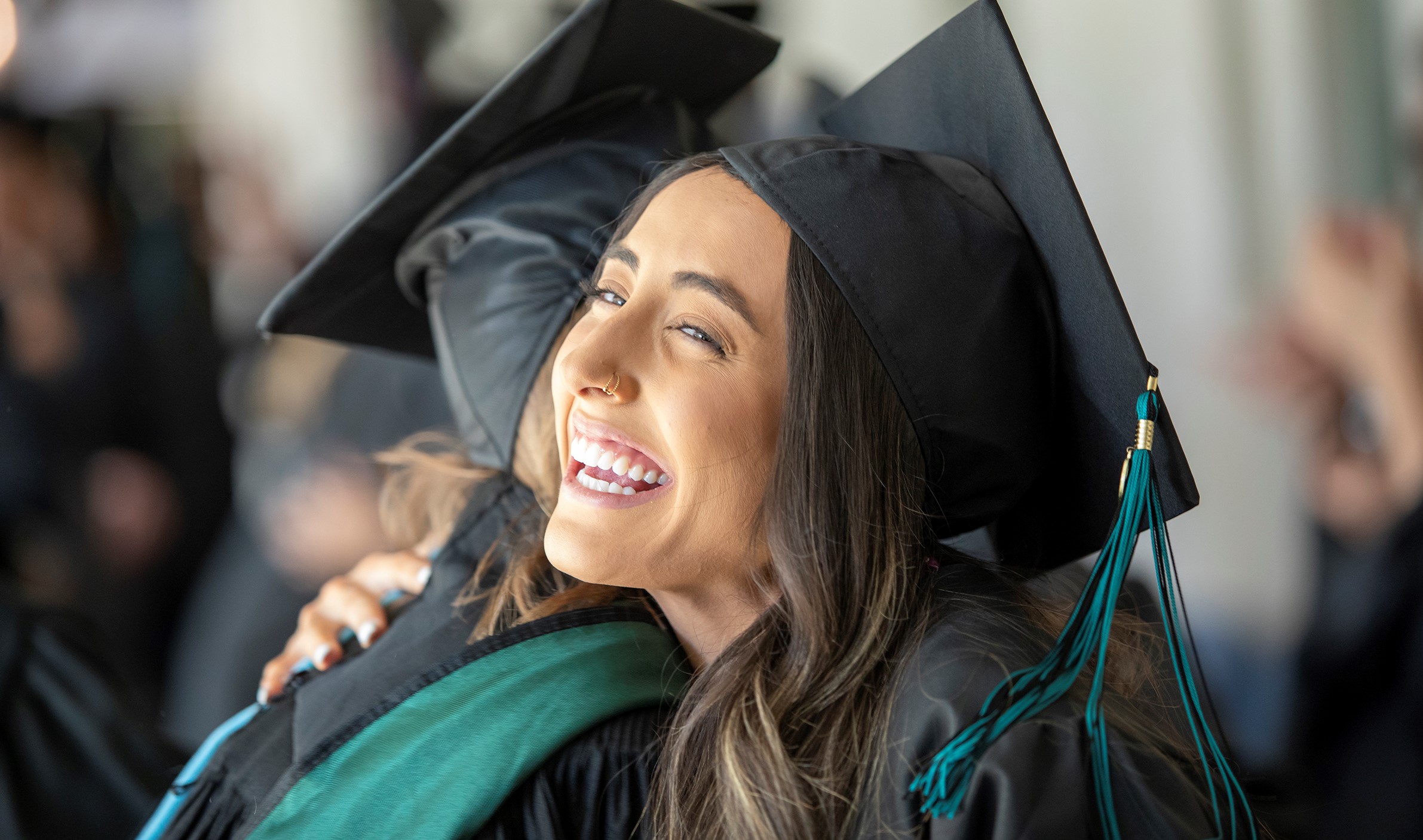 Happy student hugs friend after graduating from Coconino Community College